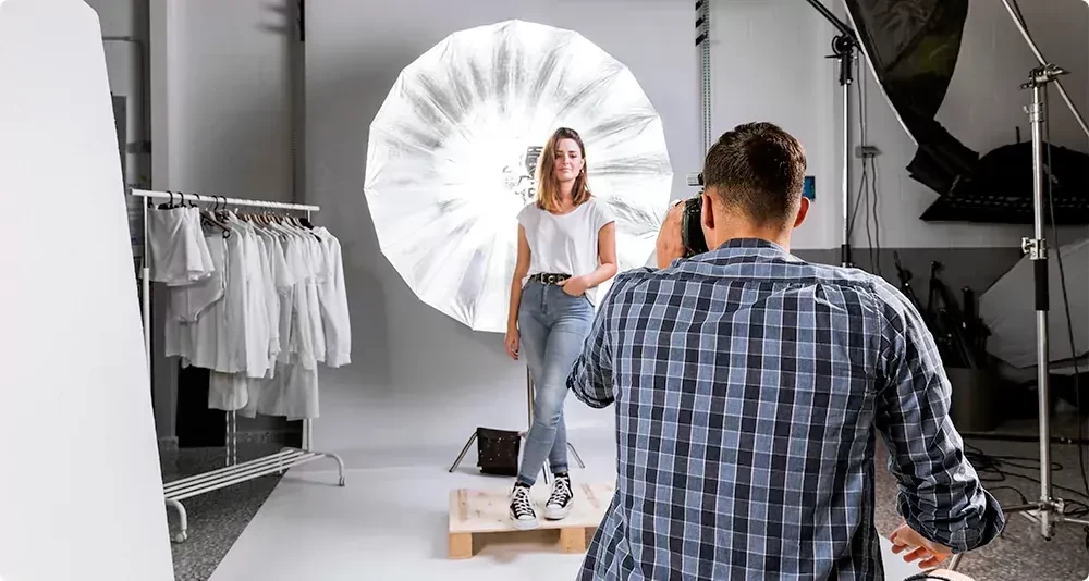 Photographer taking pictures of a model in a professional photo studio