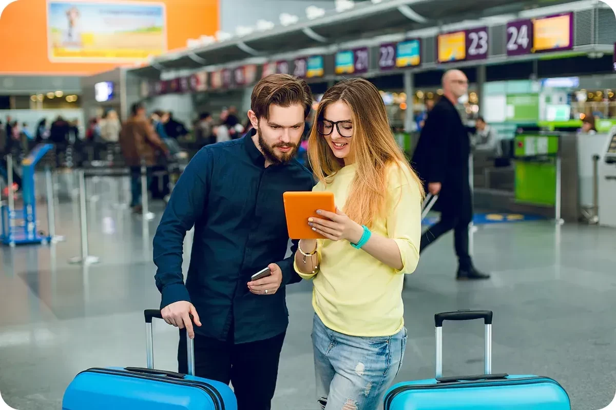 A young man and woman checking flight information at the airport