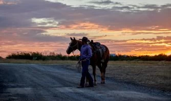 A Man And His Horse At Sunset