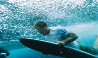 Man Diving With A Salt Life Surfboard