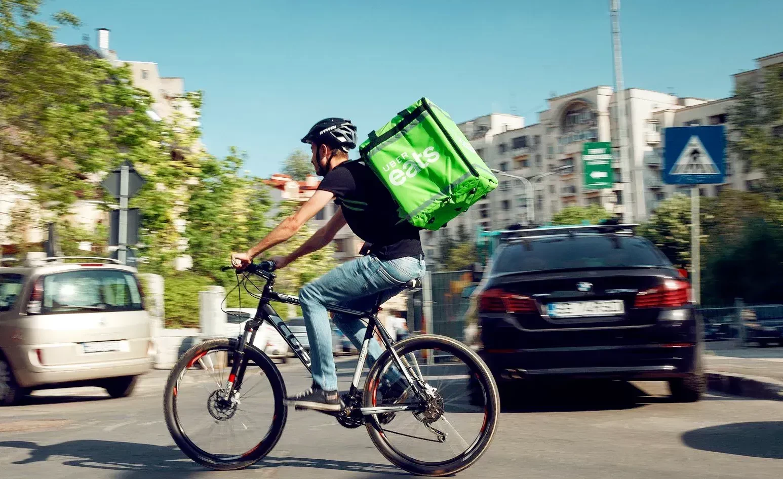 Uber Eats delivery man zips across the road on his bike